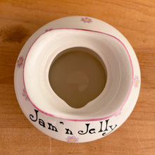 Load image into Gallery viewer, Rare vintage mid-century era Jolly Girls ceramic Jam&#39;n Jelly jar with spoon. Holt Howard, Japan, imported by LIpper and Mann, 1950s. Add this adorable kitschy piece to your collection!

In very good vintage condition, no chips/cracks/repairs, minor discolouration on the underside of the lid where the ceramic stilt pin was placed during firing. Marked Japan.

Measures 3 3/4 x 3 3/4 x 5 1/4 inches
