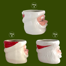 Load image into Gallery viewer, Vintage jolly red and white Santa Claus figural face ceramic mug...nostalgia from holidays gone by! Likely made for Binns Department Store in Pittsburgh, Pennsylvania and crafted in Japan, circa 1960s. Add some holiday magic to your Christmas decor by filling this charming mug with candy canes or top with an ornament!

In as found vintage condition, no chips, cracks or repairs. There is wear to the cold paint on all three mugs. Mugs A and C are marked Japan.

Measures 3 x 3 inches, not incl. handle
