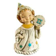 Load image into Gallery viewer, Josef Originals Gemini zodiac wizard figurine, front view — smiling girl in cream wizard hat and robe with hand-painted stars and gems, holding teal Gemini symbol medallion, 1960s Japan

