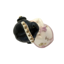 Load image into Gallery viewer, Close-up top-down view of the Josef Originals figurine head, showing the black hair bun with white and gold beaded hair band and small white headdress, hand-painted face with pink cheeks visible at edge
