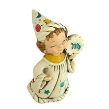 Load image into Gallery viewer, Josef Originals Virgo Zodiac wizard figurine, left three-quarter view from slightly above, showing the smiling hand-painted face, tall white wizard hat with multicolour celestial motifs, cream robe with teal stars, red suns, and teal dot details, cloud-shaped Virgo medallion held at right shoulder, yellow collar
