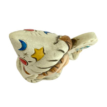 Load image into Gallery viewer, Overhead view of the Josef Originals Virgo wizard figurine hat and shoulders, showing the cream pointed wizard hat decorated with blue crescent moon, yellow star, red dot, and incised star details, brown braided hair and rope-twist collar visible below,
