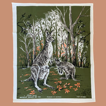 Load image into Gallery viewer, Vintage silk screened natural linen tea towel featuring an adorable kangaroo and joey standing in a forest clearing. The design is highly detailed in shades of avocado green, orange, gray, black and white. Crafted by Liddell Designs, Australia, 1960s. Tea towels make great practical kitchen and wall decor. A towel of this quality and style would make a wonderful contemporary pillow!

In excellent condition. Appears unused.

Approximately 23 1/4 x 28 1/2 inches
