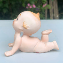Load image into Gallery viewer, Sweet vintage bisque porcelain Kewpie doll figurine with blue wings, model KW7546. Crafted by Lefton, Japan, circa 1960s. This darling Kewpie figurine is laying down on his tummy, pushed up on its hands looking skyward with one leg curled up. So cute!  In excellent condition, no chips/cracks/repairs.  Measures 3 1/4 x 2 3/4 x 2 1/2 inches
