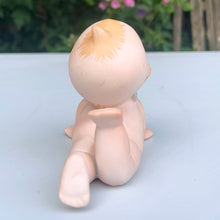 Load image into Gallery viewer, Sweet vintage bisque porcelain Kewpie doll figurine with blue wings, model KW7546. Crafted by Lefton, Japan, circa 1960s. This darling Kewpie figurine is laying down on his tummy, pushed up on its hands looking skyward with one leg curled up. So cute!  In excellent condition, no chips/cracks/repairs.  Measures 3 1/4 x 2 3/4 x 2 1/2 inches
