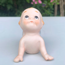Load image into Gallery viewer, Sweet vintage bisque porcelain Kewpie doll figurine with blue wings, model KW7546. Crafted by Lefton, Japan, circa 1960s. This darling Kewpie figurine is laying down on his tummy, pushed up on its hands looking skyward with one leg curled up. So cute!  In excellent condition, no chips/cracks/repairs.  Measures 3 1/4 x 2 3/4 x 2 1/2 inches
