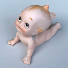 Load image into Gallery viewer, Sweet vintage bisque porcelain Kewpie doll figurine with blue wings, model KW7546. Crafted by Lefton, Japan, circa 1960s. This darling Kewpie figurine is laying down on his tummy, pushed up on its hands looking skyward with one leg curled up. So cute!  In excellent condition, no chips/cracks/repairs.  Measures 3 1/4 x 2 3/4 x 2 1/2 inches
