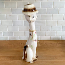 Load image into Gallery viewer, Vintage kitsch long neck, big eyed hand painted ceramic cat figurine. Crafted in Japan, 1960s. An adorable piece to add to your kitsch or cat collection!

In excellent vintage condition, no chips/cracks/repairs. There is minor glaze miss on the hat brim.

Measures 3 x 3 3/4 x 12 1/2 inches
