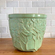 Load image into Gallery viewer, Highly collectible vintage light green roses ceramic jardiniere planter. Crafted by McCoy Pottery, USA, 1950. The perfect home for your favourite greenery or flowers! This rare piece is a must-have for any art pottery collector!

In excellent vintage condition, no chips/cracks/repairs, normal age-related crazing and manufacturer&#39;s glaze pops. Maker&#39;s mark.

Measures 7 1/2 x 6 5/8 inches
