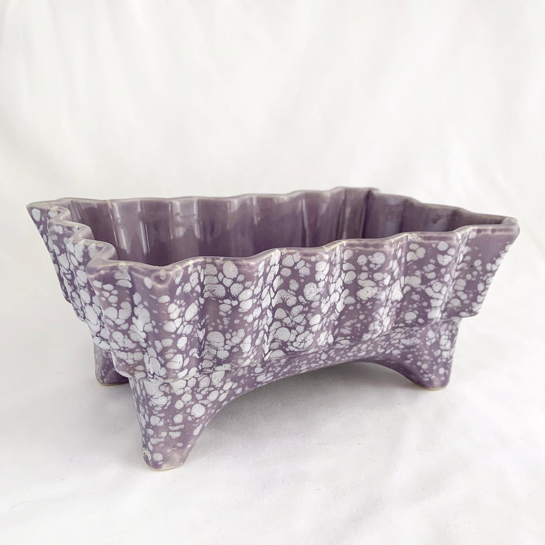 This gorgeous vintage retro lilac purple and white splatter glazed footed ceramic planter features a sawtooth edge (shape 5001). Crafted by USA Pottery, circa 1950s. What can we say, it's absolutely fabulous and any floral arrangement would be fortunate to find itself on display in this vessel!  In excellent condition, free from chips/cracks/repairs.  Measures approximately 7 7/8 x 5 3/8 x 3 1/4 inches   