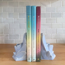 Load image into Gallery viewer, Striking vintage matte lilac water lily bookends. Crafted by Nelson McCoy Pottery, 1940s. These rare bookends are a must for any McCoy art pottery collector!

In as found vintage condition, with a couple of chips, see photos. Maker&#39;s marks on both pieces.

Measures 6 1/4 x 5 1/2 inches
