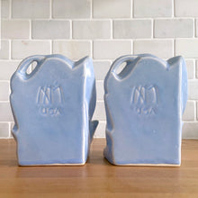 Load image into Gallery viewer, Striking vintage matte lilac water lily bookends. Crafted by Nelson McCoy Pottery, 1940s. These rare bookends are a must for any McCoy art pottery collector!

In as found vintage condition, with a couple of chips, see photos. Maker&#39;s marks on both pieces.

Measures 6 1/4 x 5 1/2 inches
