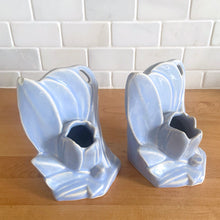 Load image into Gallery viewer, Striking vintage matte lilac water lily bookends. Crafted by Nelson McCoy Pottery, 1940s. These rare bookends are a must for any McCoy art pottery collector!

In as found vintage condition, with a couple of chips, see photos. Maker&#39;s marks on both pieces.

Measures 6 1/4 x 5 1/2 inches
