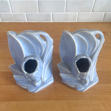 Load image into Gallery viewer, Striking vintage matte lilac water lily bookends. Crafted by Nelson McCoy Pottery, 1940s. These rare bookends are a must for any McCoy art pottery collector!

In as found vintage condition, with a couple of chips, see photos. Maker&#39;s marks on both pieces.

Measures 6 1/4 x 5 1/2 inches
