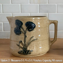Load image into Gallery viewer, Vintage natural yellow ware strapped barrel milk pitcher featuring navy lily in bas relief with rope style handle, No. 21171. Crafted by Robinson Ransbottom Pottery Co., USA, 1930s. Enhance your home&#39;s decor with this beautiful piece of primitive farmhouse tableware. A wonderful addition to any art pottery collection!

Excellent vintage condition, no chips/cracks/repairs, age-related crazing and typical manufacturer&#39;s glaze pops. Unmarked

Option 2: 5 1/4 x 5 1/4. 48 oz
