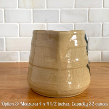 Load image into Gallery viewer, Vintage natural yellow ware strapped barrel milk pitcher featuring navy lily in bas relief with rope style handle, No. 21171. Crafted by Robinson Ransbottom Pottery Co., USA, 1930s.

Enhance your home's decor with this beautiful piece of primitive farmhouse tableware. A wonderful addition to any art pottery collection!

Option 3: Measures 4 x 4 1/2 inches. In excellent vintage condition, no chips/cracks/repairs with age-related crazing and typical manufacturer's glaze pops. Unmarked. Capacity 32 ounces
