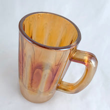 Load image into Gallery viewer, A vintage marigold carnival glass handled beer mug has great iridescence! Crafted by the Jeannette Glass Company, USA, circa 1920s/30s. Enjoy a cold one in this special piece of glass!  In excellent condition, free from chips/cracks.  Measures 3 x 5 1/2-inches tall  Capacity 10 ounces
