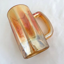 Load image into Gallery viewer, A vintage marigold carnival glass handled beer mug has great iridescence! Crafted by the Jeannette Glass Company, USA, circa 1920s/30s. Enjoy a cold one in this special piece of glass!  In excellent condition, free from chips/cracks.  Measures 3 x 5 1/2-inches tall  Capacity 10 ounces
