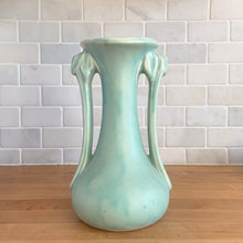 Load image into Gallery viewer, Beautiful vintage Art Deco matte aqua leaf topped handled vase. Crafted by McCoy Pottery, 1940s. This vase is must for any art pottery collector!

In as found vintage condition, area at the rim where glaze has come away, no chips/cracks/repairs. Maker&#39;s mark on the bottom.

Measures 5 1/4 x 9 1/4 inches
