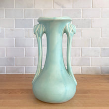 Load image into Gallery viewer, Beautiful vintage Art Deco matte aqua leaf topped handled vase. Crafted by McCoy Pottery, 1940s. This vase is must for any art pottery collector!

In as found vintage condition, area at the rim where glaze has come away, no chips/cracks/repairs. Maker&#39;s mark on the bottom.

Measures 5 1/4 x 9 1/4 inches
