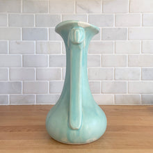 Load image into Gallery viewer, Beautiful vintage Art Deco matte aqua leaf topped handled vase. Crafted by McCoy Pottery, 1940s. This vase is must for any art pottery collector!

In as found vintage condition, area at the rim where glaze has come away, no chips/cracks/repairs. Maker&#39;s mark on the bottom.

Measures 5 1/4 x 9 1/4 inches
