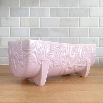 Vintage Art Deco matte pink Butterfly Line fernery. Crafted by Nelson McCoy Pottery, early 1940s. This rare piece is must for any McCoy art pottery collector!

In excellent condition, tiny flea bite on interior rim, no chips/cracks/repairs. Maker's mark.

Measures 8 1/2 x 4 x 3 3/8 inches