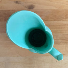 Load image into Gallery viewer, Rare vintage mid-century matte turquoise vase with decorative handle. Crafted by McCoy Pottery, 1950s. This vase is must for any art pottery collector! Makes a perfect mid-century decor statement or give as a gift.

In good condition, slim chip to the handle, no cracks/repairs. Maker&#39;s mark on the bottom.

Measures 6 x 9 inches (incl. handle/spout)
