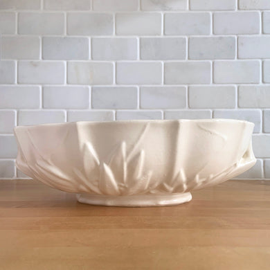 Vintage Art Deco large matte white glazed lotus centrepiece console bowl. Crafted by Nelson McCoy Pottery, 1940s. This rare piece is must for any Nelson McCoy art pottery collector!

In good vintage condition, minor flea bite on the inner edge, no cracks or repairs. Typical manufacturers glaze bubbles. Maker's mark.

Measures 12 x 7 1/2 x 4 inches