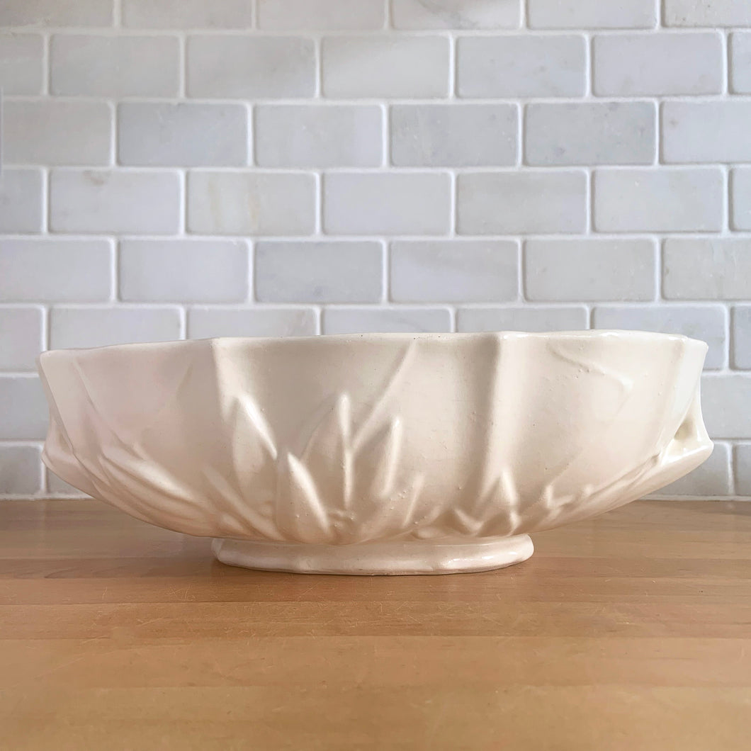 Vintage Art Deco large matte white glazed lotus centrepiece console bowl. Crafted by Nelson McCoy Pottery, 1940s. This rare piece is must for any Nelson McCoy art pottery collector!

In good vintage condition, minor flea bite on the inner edge, no cracks or repairs. Typical manufacturers glaze bubbles. Maker's mark.

Measures 12 x 7 1/2 x 4 inches