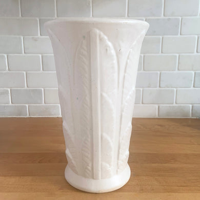Vintage art deco matte white ceramic vase featuring repeating columns of stacked palm leaves. Crafted by Robinson Ransbottom Pottery Co., USA, 1930s. A beautiful piece to add to your art pottery collection!

In excellent condition, no chips/cracks/repairs. Typical manufacturing glaze pops. Unmarked.

Measures 6 1/8 x 10 inches
