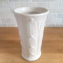 Load image into Gallery viewer, Vintage art deco matte white ceramic vase featuring repeating columns of stacked palm leaves. Crafted by Robinson Ransbottom Pottery Co., USA, 1930s. A beautiful piece to add to your art pottery collection!

In excellent condition, no chips/cracks/repairs. Typical manufacturing glaze pops. Unmarked.

Measures 6 1/8 x 10 inches
