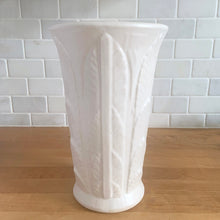 Load image into Gallery viewer, Vintage art deco matte white ceramic vase featuring repeating columns of stacked palm leaves. Crafted by Robinson Ransbottom Pottery Co., USA, 1930s. A beautiful piece to add to your art pottery collection!

In excellent condition, no chips/cracks/repairs. Typical manufacturing glaze pops. Unmarked.

Measures 6 1/8 x 10 inches
