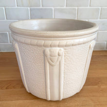 Load image into Gallery viewer, Vintage art deco matte white ceramic jardiniere planter featuring repeating straps on stippled ground with rope detail at the rim. Crafted by Robinson Ransbottom Pottery Co., USA, 1940s. A beautiful piece to add to your art pottery collection!

In excellent condition, no chips/cracks/repairs. Typical manufacturing glaze pops. Marked with crown stamp and the number 208.

Measures 8 x 6 5/8 inches
