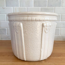 Load image into Gallery viewer, Vintage art deco matte white ceramic jardiniere planter featuring repeating straps on stippled ground with rope detail at the rim. Crafted by Robinson Ransbottom Pottery Co., USA, 1940s. A beautiful piece to add to your art pottery collection!

In excellent condition, no chips/cracks/repairs. Typical manufacturing glaze pops. Marked with crown stamp and the number 208.

Measures 8 x 6 5/8 inches
