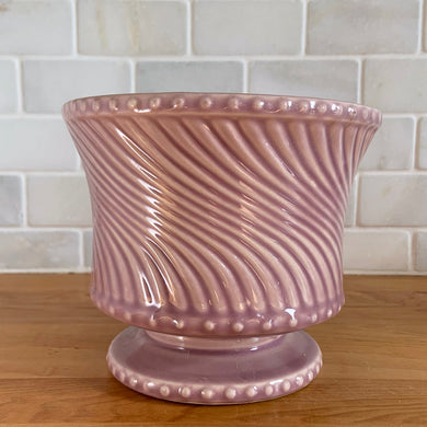 Striking vintage gloss mauve swirl footed pedestal planter pot with hobnail details. Crafted by McCoy Pottery, 1962. This rare planter is must for any McCoy art pottery collector!

In excellent vintage condition, no chips or cracks. Maker's mark on the bottom.

Measures 6 x 5 inches
