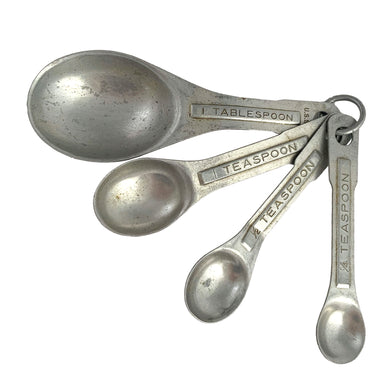 Vintage metal measuring spoon set. 1960s. The set includes four spoons: 1/4 teaspoon, 1/2 teaspoon, 1 teaspoon, 1 tablespoon and each attaches to a ring to keep them organized. The perfect gift for any vintage kitchenware collector, baker or cook.

In used vintage condition.