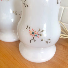 Load image into Gallery viewer, A beautifully shaped pair of vintage milk glass table lamps featuring hand painted flowers in orange, green and gold. Perfect for adding vintage charm to any space. In as found vintage condition, glass is free from chips/cracks, paint is worn. Tested and in working order. Measures 3 7/8 x 12 1/4 inches
