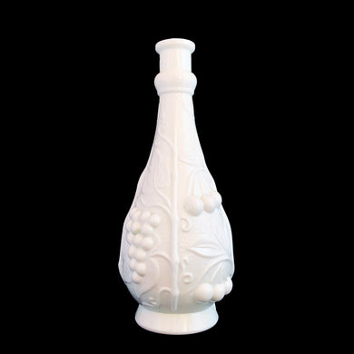 Vintage milk glass genie bottle featuring an embossed pattern of cherries and grapevines. Produced by glass artisans in the Empoli region of Italy. This superb mid-century piece of art glass would make a unique addition to your home decor collection. Perfect as a decanter, vase or decor piece. Dates between 1950 to 1970. These bottles are incredibly fabulous and highly collectible.

In excellent vintage condition, no chips. Unmarked. No stopper.

Measures 4 x 10 1/2 inches