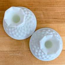 Load image into Gallery viewer, Pair of vintage milk glass &quot;Hobnail&quot; single lite candlesticks. Crafted by Fenton Art Glass, USA, 1970s. Fill with taper candles to add charming elegance to your home&#39;s decor!  In excellent condition, free from chips. Marked with the Fenton logo.  Measures 4 1/4 x 3 1/2 inches
