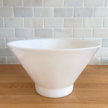 Load image into Gallery viewer, Elevate your table with this large vintage milk glass serving bowl, featuring a bold conical silhouette that embodies Modernist design. While Anchor Hocking produced a similar clear version, this piece's maker remains a mystery—adding to its vintage charm. Versatile and elegant, it's equally at home presenting a fresh salad, your favorite snacks, or as centerpiece filled with fruit. The perfect combination of nostalgia and contemporary style.

In excellent condition, no chips.

Measures 10 3/4 x 6 inches
