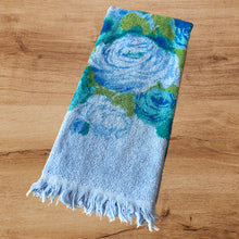 Load image into Gallery viewer, Vintage Monticello 100% cotton blue terry cloth hand towel featuring a pattern of blue, teal and green flowers with fringe edges. Crafted by Cannon Mills, USA, circa 1970s.  In excellent used condition, free from stains/tears. Measures 16 x 28 inches
