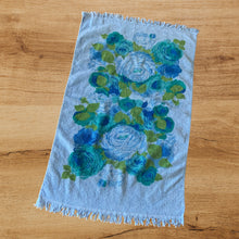 Load image into Gallery viewer, Vintage Monticello 100% cotton blue terry cloth hand towel featuring a pattern of blue, teal and green flowers with fringe edges. Crafted by Cannon Mills, USA, circa 1970s.  In excellent used condition, free from stains/tears. Measures 16 x 28 inches
