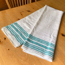 Load image into Gallery viewer, Vintage natural cotton linen tablecloth featuring wide and narrow turquoise green stripes. Give your table a touch of rustic charm with this grain sack style table covering. Perfect for farmhouse, shabby chic and cottage core decor styles.

In excellent condition, free from stains/tears

Tablecloth measures 52 x 78 inches
