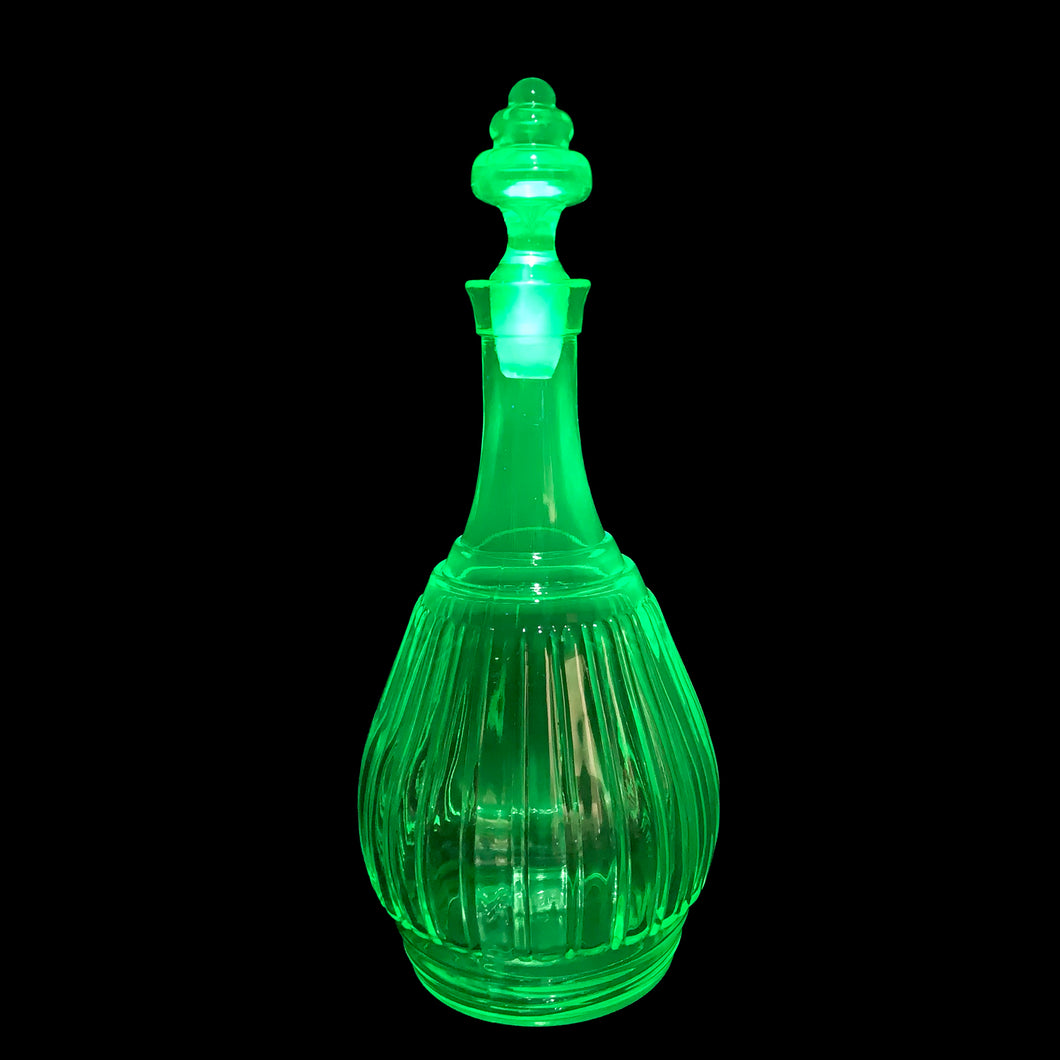 Vintage New Century Green Uranium Glass Decanter, Hazel-Atlas Glass, USA, 1930 - 1935. Glows brilliantly under black light. A wonderful addition to your glowy glass collection... perfect for a spooky barware display too!

In excellent condition, no chips to the decanter, chipping to the end of the stopper.

Measures 4 3/4 x 10 1/2 inches