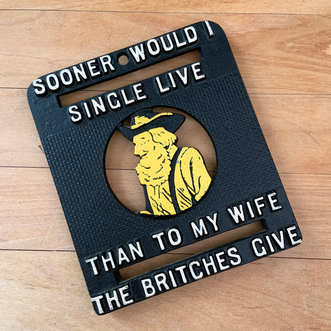 Vintage novelty cast iron trivet depicting a bearded man in yellow with the saying, Sooner Would I Single LIve Than to My Wife The Britches Give. Use as wall decor or as intended. A fun and practical conversation piece for your cottage or farmhouse kitchen decor!

In excellent condition.

Measures 4 1/2 x 4 3/4 inches