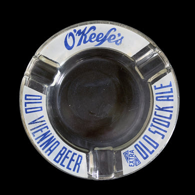 Vintage promotional advertising O'Keefe's old Vienna Beer / Extra Old Stock Ale clear round glass ashtray. A great piece for the tobacciana and barware collector.  In vintage condition, minor flea bites to the interior rim and wear to the printing.  Measures 6 1/8 x 7/8 inches