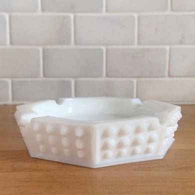 Vintage octagonal Hobnail milk glass ashtray. Crafted by Fenton Art Glass, USA, pre-1970. A perfect addition to any decor style, it offers a sense of understated elegance, as well as versatility - use as an ashtray, or repurpose it to store trinkets, jewelry, or even soap!

In excellent condition, no chips or cracks. Unmarked.

Measures 5 3/8 x 5 3/8 x 1 1/8 inches