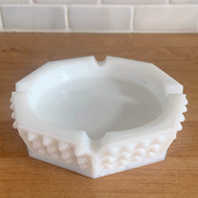 Load image into Gallery viewer, Vintage octagonal Hobnail milk glass ashtray. Crafted by Fenton Art Glass, USA, pre-1970. A perfect addition to any decor style, it offers a sense of understated elegance, as well as versatility - use as an ashtray, or repurpose it to store trinkets, jewelry, or even soap!

In excellent condition, no chips or cracks. Unmarked.

Measures 5 3/8 x 5 3/8 x 1 1/8 inches
