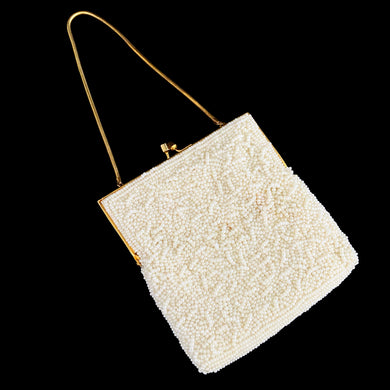 Stunning handmade vintage mid-century era evening bag adorned in creamy off-white glass seed beads, topped with gold-toned hardware, snake chain handle and kiss closure. The interior is lined with cream satin and has an open pocket. The bag is large enough for a small cell phone, credit cards/cash, compact/lipstick. Beautifully styled by Artel Montreal and made in Hong Kong, 1950s. An absolutely stunning piece that would make an incredible bridal or formal occasion accessory!