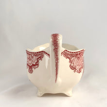 Load image into Gallery viewer, Vintage pink transferware Old Britain Castles creamer. Crafted by Johnson Bros, England, 1930 - 2003. A lovely way to enhance your tea and coffee experience!

In as found condition, inner chip to one of the feet, no cracks or repairs. Maker&#39;s mark on the bottom.

Measures 6 1/4 x 3 5/8 x 2 7/8 inches (incl. handle)

Capacity 8 ounces
